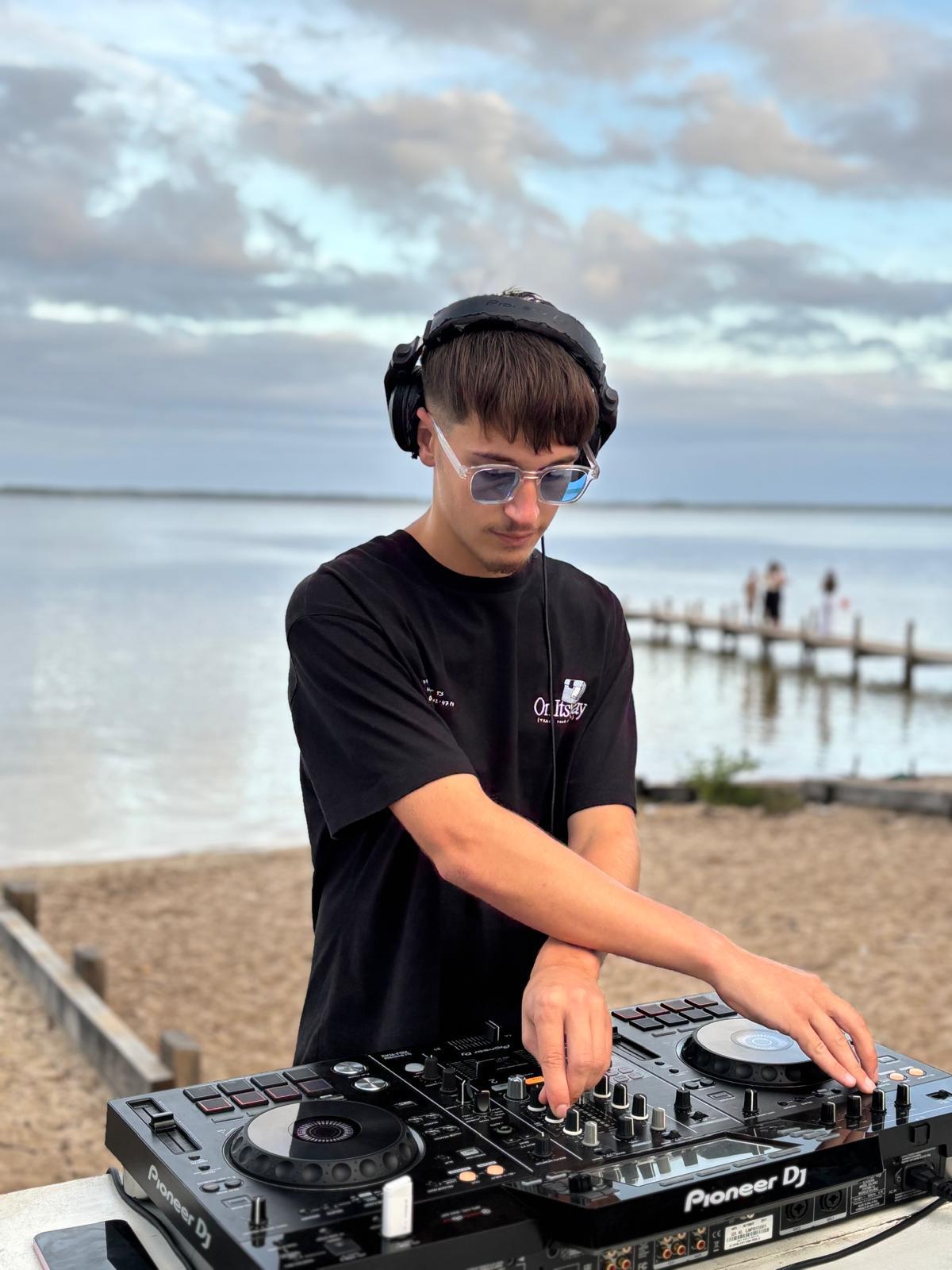 DJ Huko en set au bord de l'eau au coucher du soleil